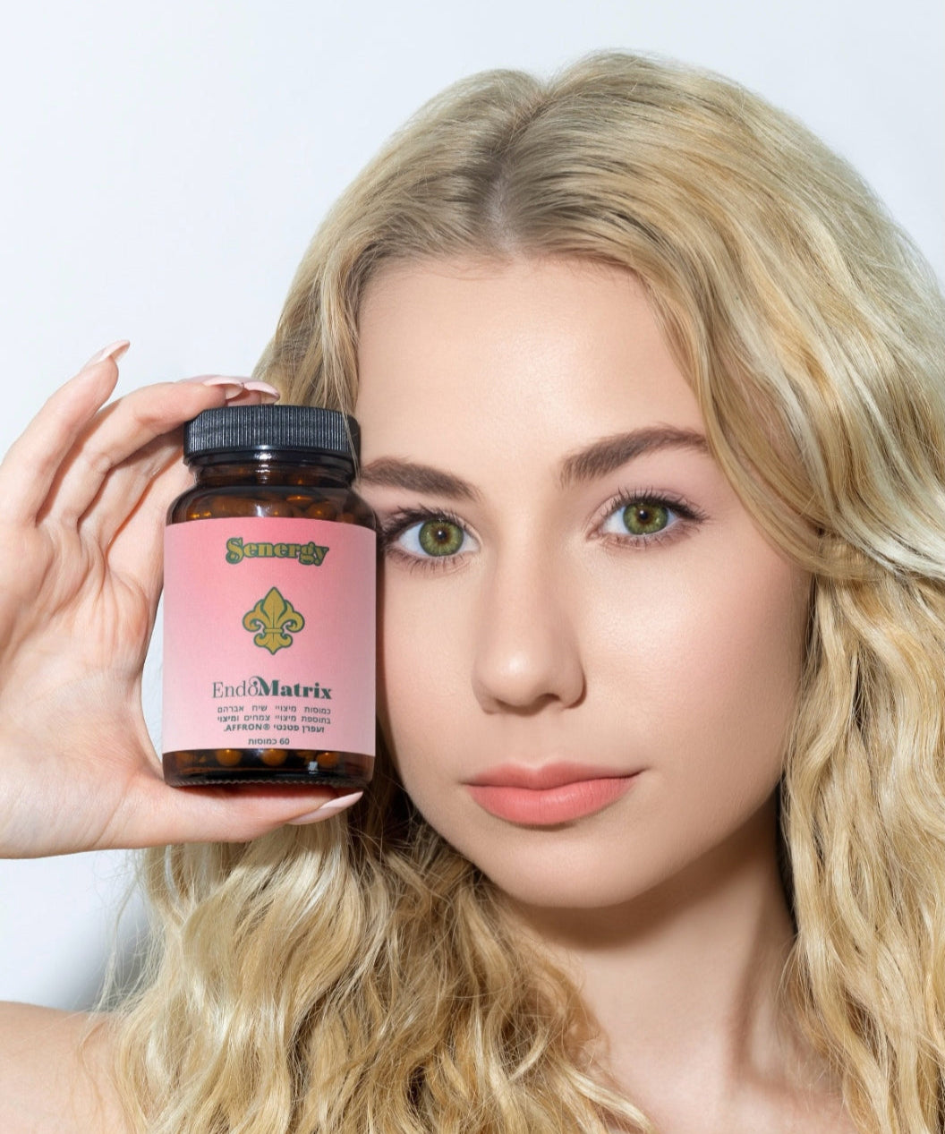 אישה מחזיקה את תוסף אנדומטריקס של Senergy בצד הפנים – לאיזון הורמונלי, כאבי מחזור, אנדומטריוזיס ונפיחות
